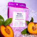 Wild Black Plum Pedi in a Box Ultimate 6 Step box with water being poured on top. Plums cut in half in the foreground.