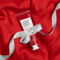 Peppermint Swirl lotion on top of red fabric with white bow