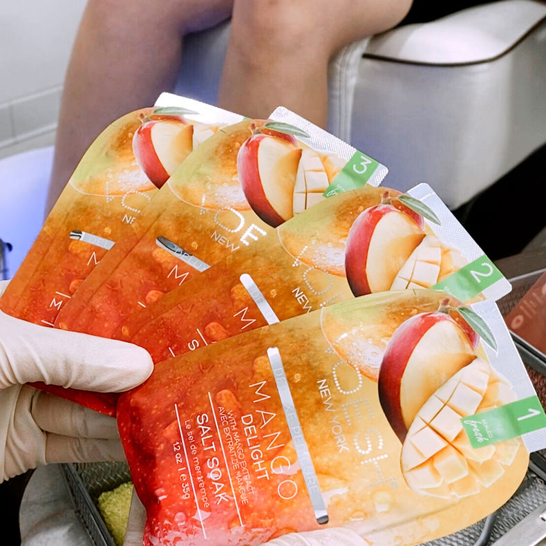 Woman holding Pedi 4 step Mango satchet at Lotus Nail Spa