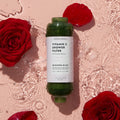 Vitamin C Shower Filter Blossom Bliss next to roses on a pink water background.