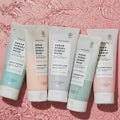 Five Sugar Scrub + Bubble Washes in each scent lined up on a pink water background.