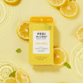 Pedi In a box 3 step lemon quench in water on a yellow background with lemon slices