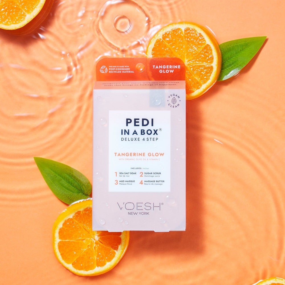 tangerine glow pedi in a box 4 step on orange background in water with tangerine slices and green leaves
