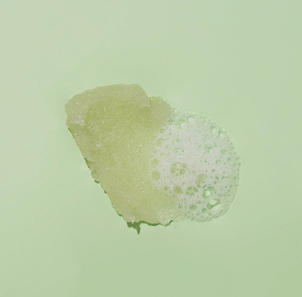 Texture of sugar scrub with bubble on green background