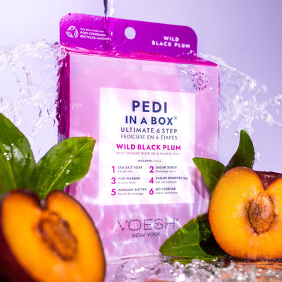 Wild Black Plum Pedi in a Box Ultimate 6 Step box with water being poured on top. Plums cut in half in the foreground.