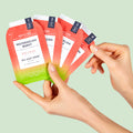 Image shows woman holding sachet of VOESH Watermelon Burst Pedi in a Box 4 Step