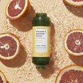 Citrus Crush shower filter on orange background with slices of citrus fruits in water