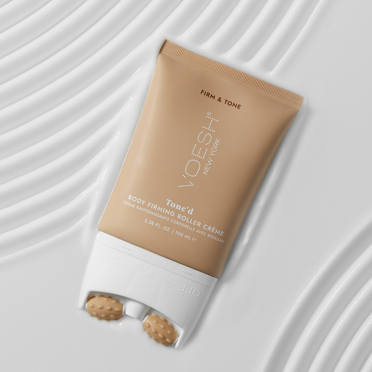 Tone’d Body Firming Roller Crème on top of lines of creamy texture on a white background.